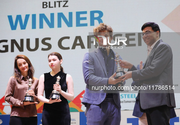 Norway's Magnus Carlsen, a chess grandmaster and five-time World Chess Champion, receives the winner's trophy from Indian chess grandmaster...