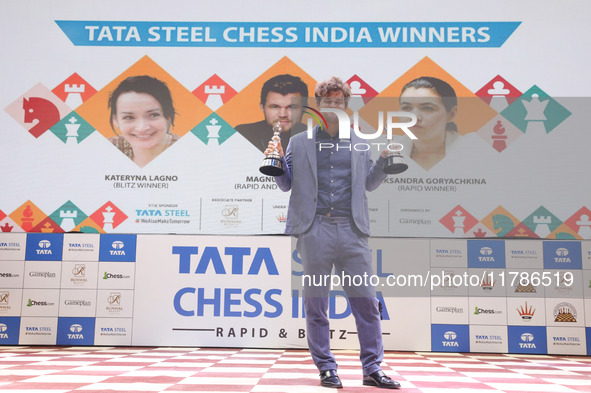 Norway's Magnus Carlsen poses for a picture with his trophies after winning the Open Rapid and Blitz Chess at the Tata Steel Chess India Tou...