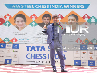 Norway's Magnus Carlsen poses for a picture with his trophies after winning the Open Rapid and Blitz Chess at the Tata Steel Chess India Tou...