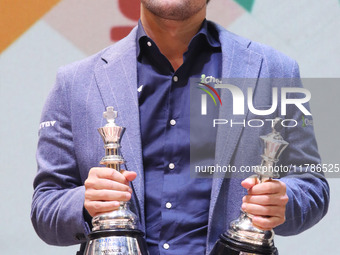 Norway's Magnus Carlsen poses for a picture with his trophies after winning the Open Rapid and Blitz Chess at the Tata Steel Chess India Tou...