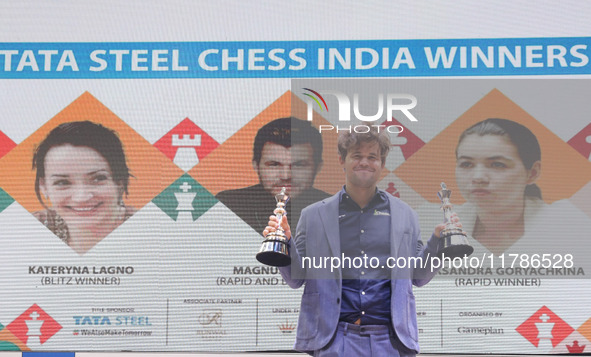 Norway's Magnus Carlsen poses for a picture with his trophies after winning the Open Rapid and Blitz Chess at the Tata Steel Chess India Tou...