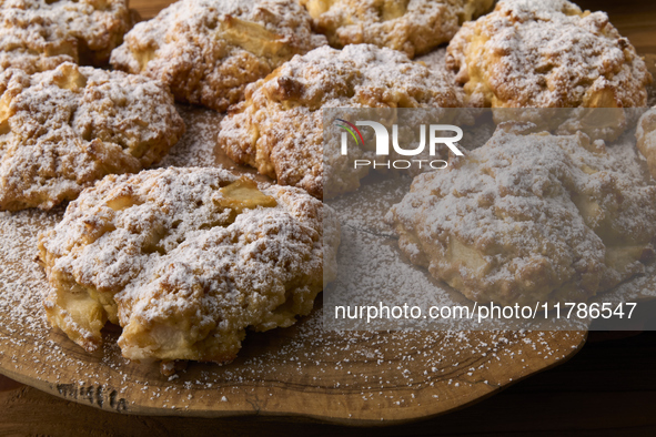 Close-up of artisanal apple and cinnamon cookies sprinkled with powdered sugar, arranged on a rustic olive wood board in City, Country, on N...