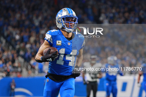 DETROIT,MICHIGAN-November 17: Detroit Lions wide receiver Amon-Ra St. Brown (14) runs the ball for a touchdown during the first half of an N...