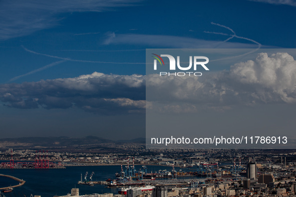 Israeli warplanes leave contrails in the sky above Haifa, Israel, on November 17, 2024. 