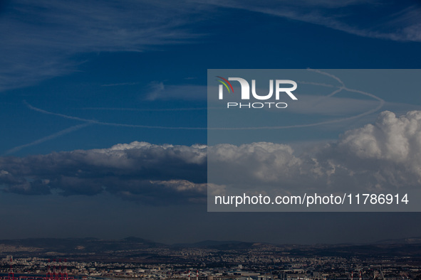 Israeli warplanes leave contrails in the sky above Haifa, Israel, on November 17, 2024. 