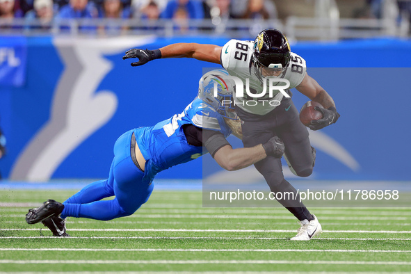 DETROIT,MICHIGAN-NOVEMBER17:  Tight end Brenton Strange (85) of the Jacksonville Jaguars carries the ball under the pressure of linebacker A...