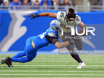 DETROIT,MICHIGAN-NOVEMBER17:  Tight end Brenton Strange (85) of the Jacksonville Jaguars carries the ball under the pressure of linebacker A...