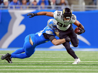 DETROIT,MICHIGAN-NOVEMBER17:  Tight end Brenton Strange (85) of the Jacksonville Jaguars carries the ball under the pressure of linebacker A...