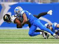 DETROIT,MICHIGAN-NOVEMBER17:  Tght end Brenton Strange (85) of the Jacksonville Jaguars is tackled by safety Brian Branch (32) of the Detroi...