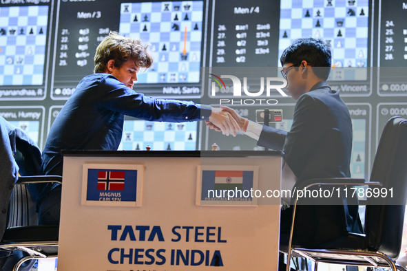 Norwegian GM Magnus Carlsen (L) shakes hands after playing a Blitz round of chess against Indian GM Rameshbabu Praggnanandhaa (R) during the...