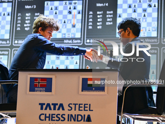 Norwegian GM Magnus Carlsen (L) shakes hands after playing a Blitz round of chess against Indian GM Rameshbabu Praggnanandhaa (R) during the...