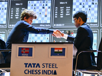 Norwegian GM Magnus Carlsen (L) shakes hands after playing a Blitz round of chess against Indian GM Rameshbabu Praggnanandhaa (R) during the...