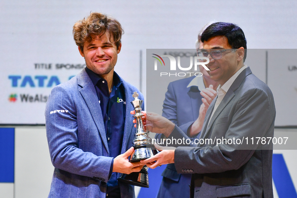 Norwegian GM Magnus Carlsen receives the winning trophy for the ''Blitz round'' chess from Indian GM Viswanathan Anand during the 6th TATA S...