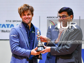 Norwegian GM Magnus Carlsen receives the winning trophy for the ''Blitz round'' chess from Indian GM Viswanathan Anand during the 6th TATA S...