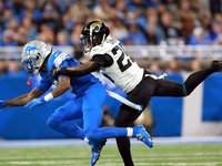 DETROIT,MICHIGAN-NOVEMBER17:  Wide receiver Jameson Williams (9) of the Detroit Lions is stopped by cornerback Ronald Darby (25) of the Jack...