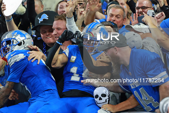 DETROIT,MICHIGAN-November 17: Detroit Lions wide receiver Amon-Ra St. Brown (14) celebrates with fans after scoring a touchdown during the s...