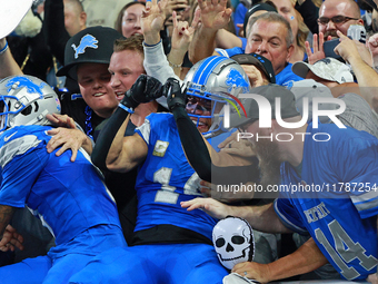 DETROIT,MICHIGAN-November 17: Detroit Lions wide receiver Amon-Ra St. Brown (14) celebrates with fans after scoring a touchdown during the s...