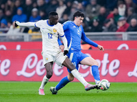 Alessandro Bastoni of Italy and Randal Kolo Muani of France compete for the ball during the UEFA Nations League 2024/25 League A Group 2 mat...