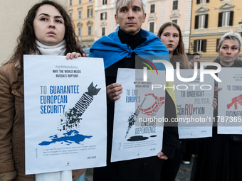 Protesters hold signs as they gather to participate in a demonstration marking the upcoming anniversary of 1,000 days since Russia's invasio...