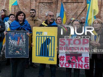 Protesters hold signs as they gather to participate in a demonstration marking the upcoming anniversary of 1,000 days since Russia's invasio...