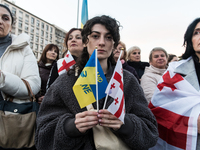 Protesters hold signs as they gather to participate in a demonstration marking the upcoming anniversary of 1,000 days since Russia's invasio...