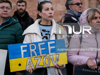 Protesters hold signs as they gather to participate in a demonstration marking the upcoming anniversary of 1,000 days since Russia's invasio...