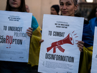 Protesters hold signs as they gather to participate in a demonstration marking the upcoming anniversary of 1,000 days since Russia's invasio...