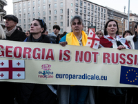 Protesters hold signs as they gather to participate in a demonstration marking the upcoming anniversary of 1,000 days since Russia's invasio...