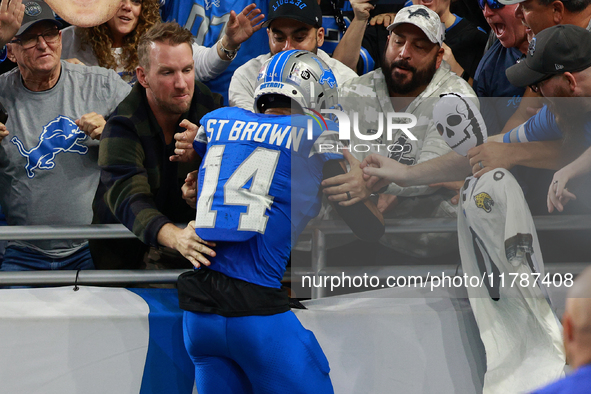 DETROIT,MICHIGAN-November 17: Detroit Lions wide receiver Amon-Ra St. Brown (14) celebrates with fans after scoring a touchdown during the s...