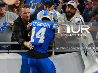 DETROIT,MICHIGAN-November 17: Detroit Lions wide receiver Amon-Ra St. Brown (14) celebrates with fans after scoring a touchdown during the s...