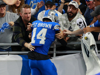 DETROIT,MICHIGAN-November 17: Detroit Lions wide receiver Amon-Ra St. Brown (14) celebrates with fans after scoring a touchdown during the s...