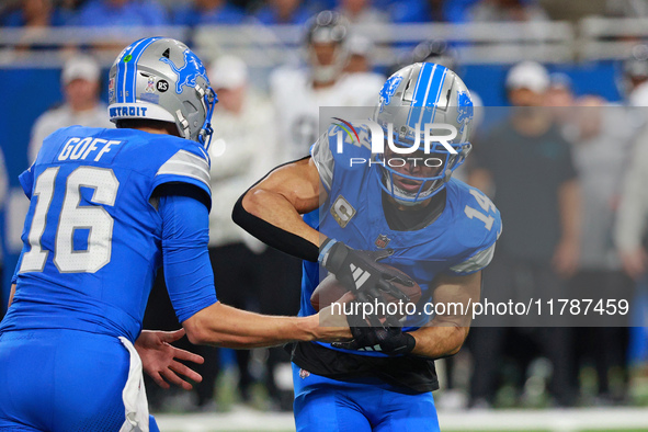 DETROIT,MICHIGAN-November 17: Detroit Lions quarterback Jared Goff (16) handles the ball off to wide receiver Amon-Ra St. Brown (14) during...