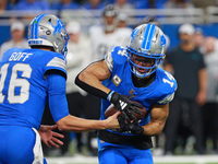 DETROIT,MICHIGAN-November 17: Detroit Lions quarterback Jared Goff (16) handles the ball off to wide receiver Amon-Ra St. Brown (14) during...