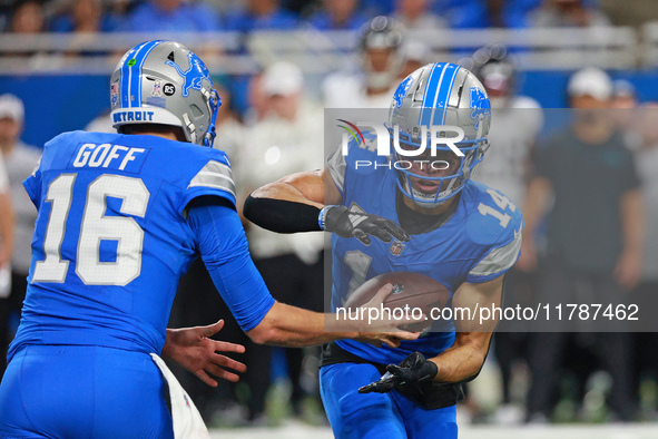 DETROIT,MICHIGAN-November 17: Detroit Lions quarterback Jared Goff (16) handles the ball off to wide receiver Amon-Ra St. Brown (14) during...