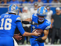 DETROIT,MICHIGAN-November 17: Detroit Lions quarterback Jared Goff (16) handles the ball off to wide receiver Amon-Ra St. Brown (14) during...