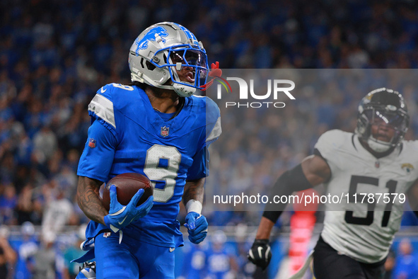 DETROIT,MICHIGAN-November 17: Detroit Lions wide receiver Jameson Williams (9) runs the ball for a touchdown during the second half of an NF...