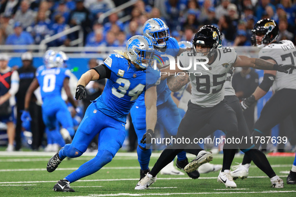 DETROIT,MICHIGAN-November 17: Jacksonville Jaguars tight end Brenton Strange (85) defends against Detroit Lions linebacker Alex Anzalone (34...