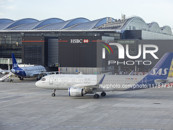 SAS Connect Airbus A320neo aircraft spotted taxiing at London Heathrow Airport LHR in front of the terminal and the air control tower. The m...