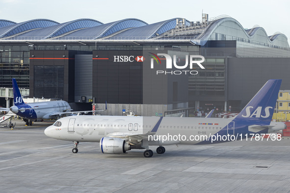 SAS Connect Airbus A320neo aircraft spotted taxiing at London Heathrow Airport LHR in front of the terminal and the air control tower. The m...