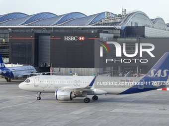 SAS Connect Airbus A320neo aircraft spotted taxiing at London Heathrow Airport LHR in front of the terminal and the air control tower. The m...