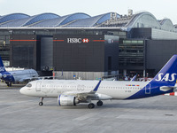 SAS Connect Airbus A320neo aircraft spotted taxiing at London Heathrow Airport LHR in front of the terminal and the air control tower. The m...