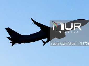 Silhouette of the isolated aircraft, passing in front of the sun. 
United Airlines Boeing 737 MAX 8 aircraft spotted departing from LaGuardi...