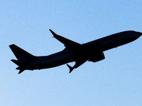 Silhouette of the isolated aircraft, passing in front of the sun. 
United Airlines Boeing 737 MAX 8 aircraft spotted departing from LaGuardi...