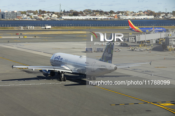 JetBlue Airbus A320-200 passenger aircraft spotted taxiing in LaGuardia airport LGA in New York City while a Southwest Boeing 737 is taxiing...