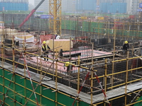 Workers work at a housing project site in Xi'an, Shaanxi province, China, on November 12, 2024. (