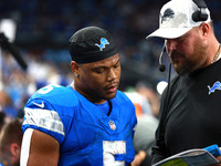 DETROIT,MICHIGAN-November 17: Detroit Lions offensive line Hank Fraley talks to running back David Montgomery (5) during the second half of...