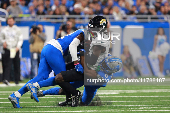 DETROIT,MICHIGAN-November 17: Jacksonville Jaguars wide receiver Brian Thomas Jr. (7) is tackled by Detroit Lions cornerback Terrion Arnold...