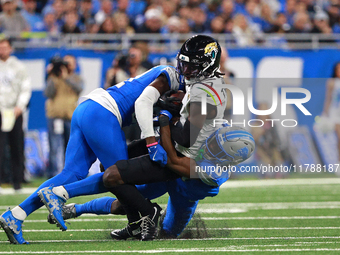 DETROIT,MICHIGAN-November 17: Jacksonville Jaguars wide receiver Brian Thomas Jr. (7) is tackled by Detroit Lions cornerback Terrion Arnold...