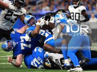 DETROIT,MICHIGAN-November 17: Detroit Lions running back Jahmyr Gibbs (26) is tackled during the second half of an NFL football game between...