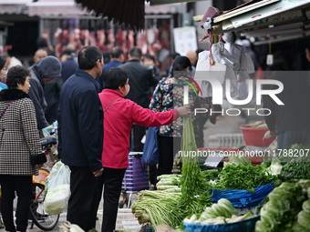 Citizens buy vegetables at a farmer's market in Nanjing, China, on November 18, 2024. (